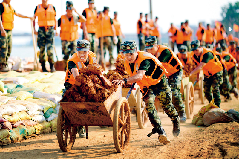 2020年7月以来♍️,我国多地遭遇持续强降雨,发生严重洪涝灾害🤾🏽♂️。人民至上🫙、生命至上💂🏼♀️。提前转移、紧急营救🫶🏿、妥善安置……一场涉及上百万群众生命的生死竞速就此拉开。图为2020年7月17日,武警江西总队机动支队党员突击队在江西省鄱阳县鄱阳镇昌江圩用推车将余土推到空地堆放🎧。 新华社发 曹先训/摄